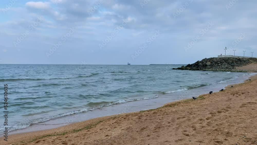 The waves of the sea roll on the sandy shore on a cloudy day. A storm or storm is coming. Rest and walk on the sea The waves of the sea roll on the sandy shore on a cloudy day. A storm or storm is coming. Rest and walk on the sea
