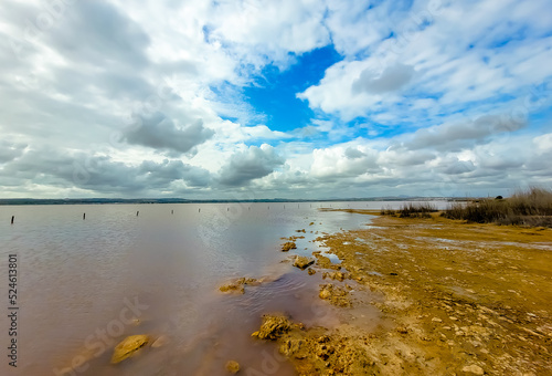 Blue clouds over pink salt lake in Torrevieja, Spain photo