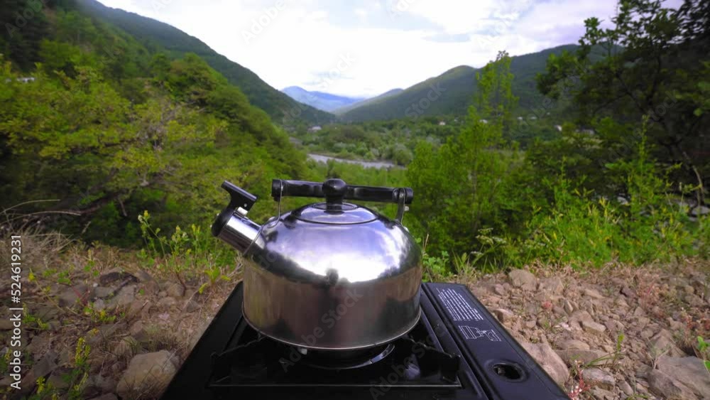 Tourist gas stove with high kettle with amazing scenery on autumn sunny day in mountains. Camp kitchen and tea making facilities. Kettle is boiling. Gonny landscape Tourist gas stove with high kettle with amazing scenery on autumn sunny day in mountains. Camp kitchen and tea making facilities. Kettle is boiling. Gonny landscape