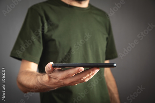 Caucasian man holding smartphone at home.