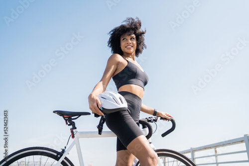 A woman is happy, a sports cyclist uses a road bike for training, a comfortable cycling suit.