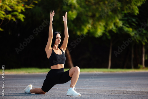 Young woman practicing yoga, doing Virabhadrasana 1 exercise, Warrior one pose, outdoor full length, 