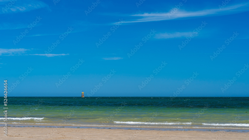 Panoramic view of beach with navigation pilot in sea and sky in background at sunset
