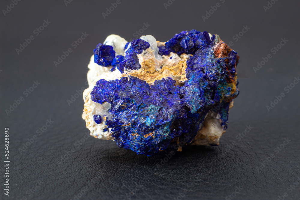 Macro blue azurite cluster on white matrix isolated crystal on black background 
