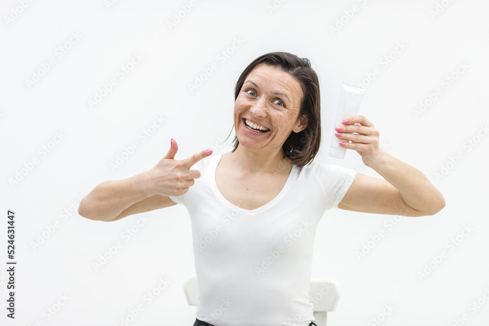 Photo of positive woman holding a cream in hand on white background. Photo of positive woman holding a cream in hand on white background.