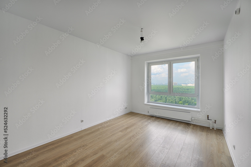 Empty room after repairs in an apartment building. Standard, stereotype fresh renovated room with wooden floor Empty room after repairs in an apartment building. Standard, stereotype fresh renovated room with wooden floor