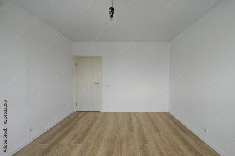 Empty room after repairs in an apartment building. Standard, stereotype fresh renovated room with wooden floor Empty room after repairs in an apartment building. Standard, stereotype fresh renovated room with wooden floor
