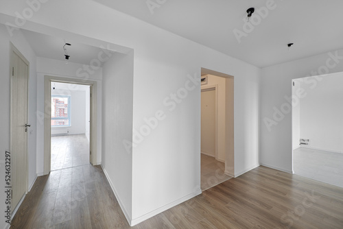 Empty room after repairs in an apartment building. Standard, stereotype fresh renovated room with wooden floor