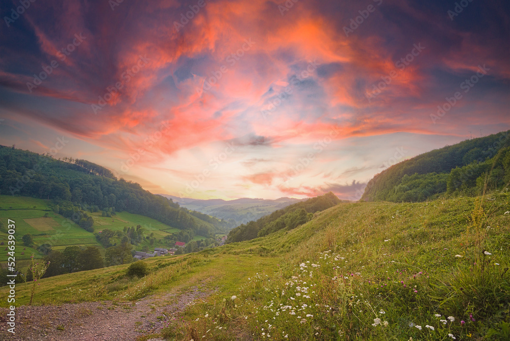 Obraz premium beautiful sunrise in the mountain area. the sky plays with warm colors. hills with fields and forests. countryside. summer season. Breathtaking nature scenery during sunset.
