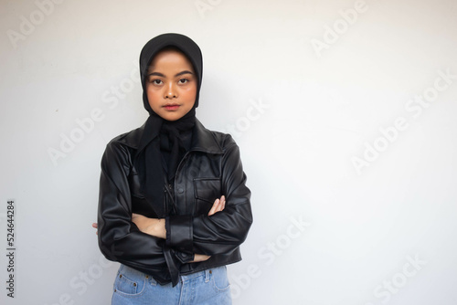 Serious young Asian Muslim woman crossing hands makes annoyed gesture and demonstrates seriousness isolated over white background