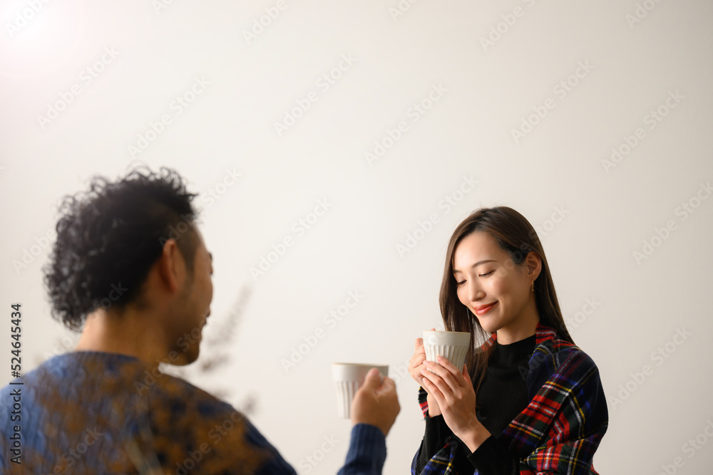 カップルでくつろぎ飲み物を飲む二人 秋冬 カップルでくつろぎ飲み物を飲む二人 秋冬