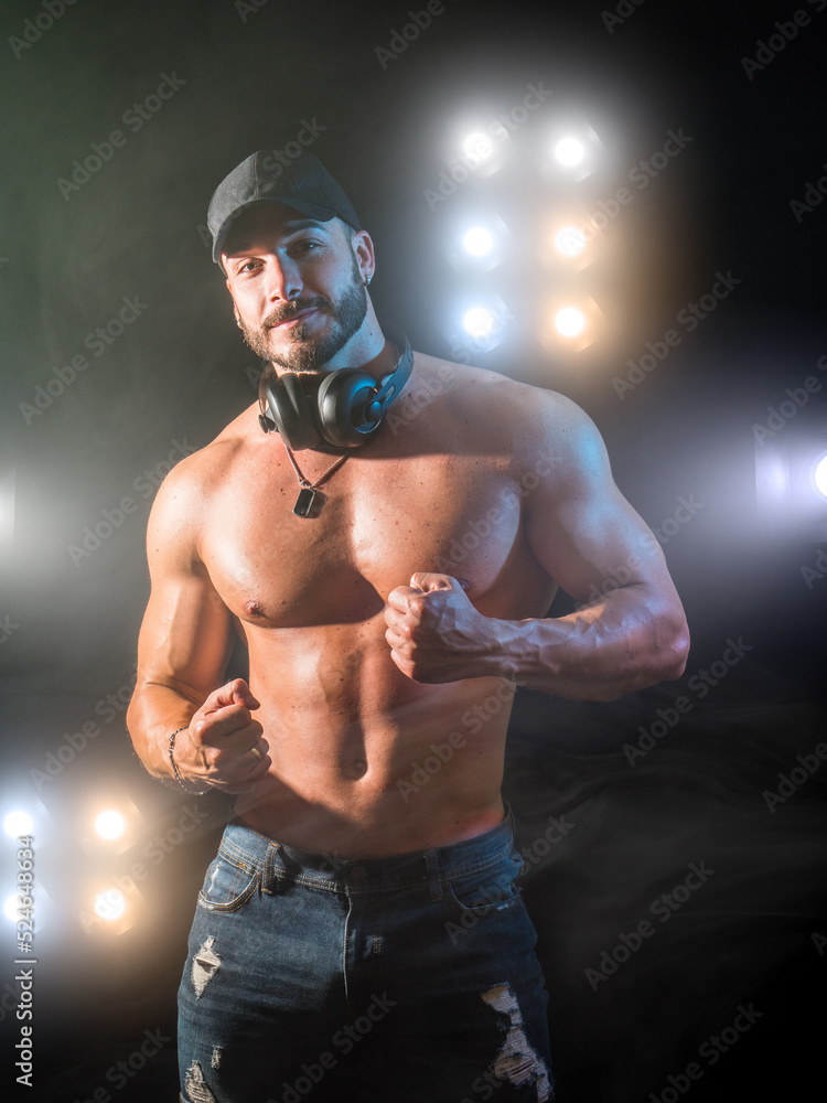 Shirtless muscular male bodybuilder in studio shot on black