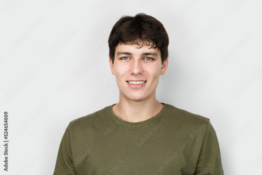 A young boy, still a happy teenager, smiling on a light background, wearing a khaki T-shirt, the boy has dark hair and white healthy teeth. The boy is in a good mood and is not depressed A young boy, still a happy teenager, smiling on a light background, wearing a khaki T-shirt, the boy has dark hair and white healthy teeth. The boy is in a good mood and is not depressed