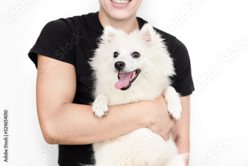 A young man holds a happy cheerful dog in his arms, the boy is also happy and smiling, he dreamed of a faithful friend, a pet since childhood, the focus is on the dog