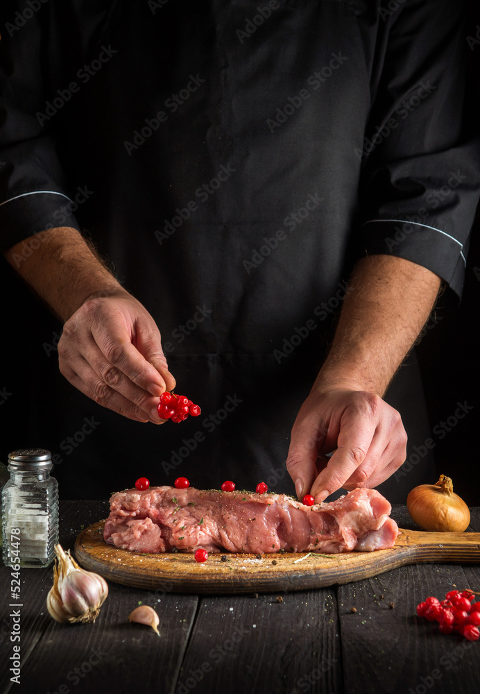 The chef prepares raw calf meat. Before baking, the cook puts the viburnum on the beef. National dish