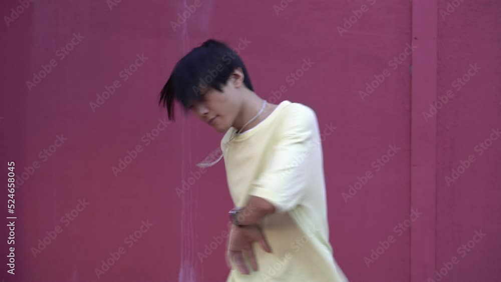 Young man dancing hip hop in the street. Contemporary Asian dancer outdoors dancing hip hop Young man dancing hip hop in the street. Contemporary Asian dancer outdoors dancing hip hop