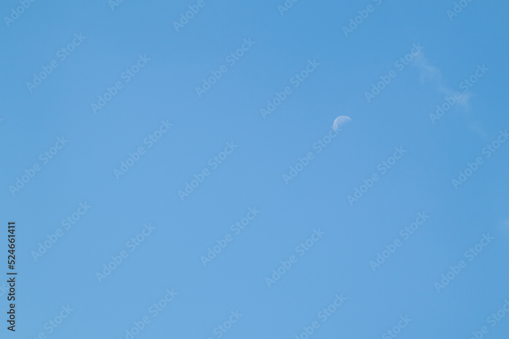 Blue sky background and white clouds soft focus, pastel sky. The moon is high in the sky. Blue sky background and white clouds soft focus, pastel sky. The moon is high in the sky.