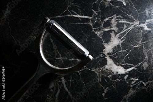 vegetable peeler on marble table top view close-up