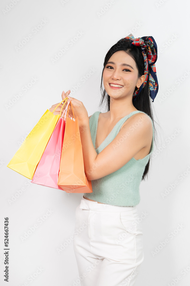Photo of a young beautiful and elegant asian woman holding colorful shopping bags with a good nice friendly smile and different poses and emotion Photo of a young beautiful and elegant asian woman holding colorful shopping bags with a good nice friendly smile and different poses and emotion