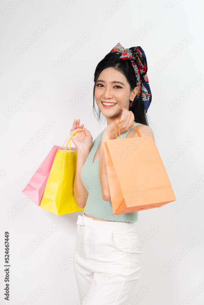 Photo of a young beautiful and elegant asian woman holding colorful shopping bags with a good nice friendly smile and different poses and emotion Photo of a young beautiful and elegant asian woman holding colorful shopping bags with a good nice friendly smile and different poses and emotion