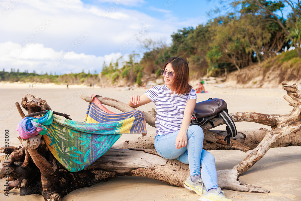 オーストラリアのバイロンベイのビーチで景色を楽しむバックパッカーの日本人女性