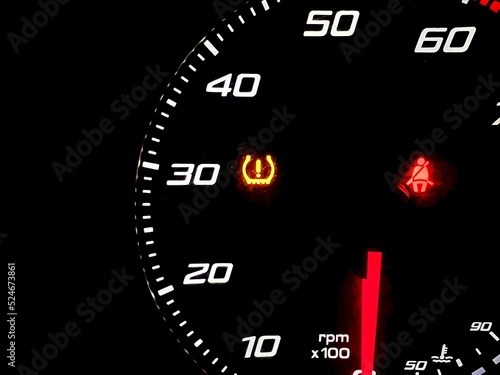 car dashboard panel with light signal the belt is not fastened and the tire pressure is low. car safety concept, travel, vacation. vehicle check and control.