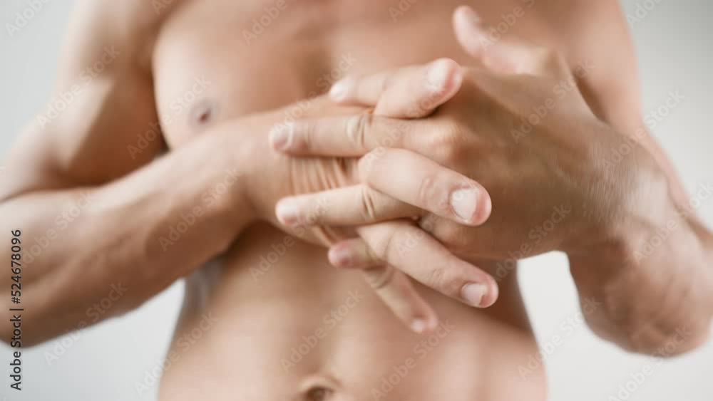 Athletic Man Naked to the Torso Kneads His Hands on a White Background. Arm Joint Pain. Concept of Problems with Joints and Ligaments. Arthritis and Arthrosis. Unrecognizable Person. Close-up. Athletic Man Naked to the Torso Kneads His Hands on a White Background. Arm Joint Pain. Concept of Problems with Joints and Ligaments. Arthritis and Arthrosis. Unrecognizable Person. Close-up.