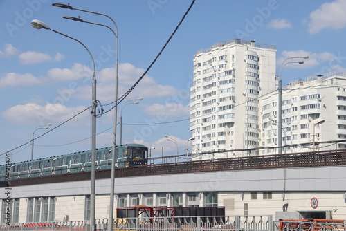 The train of the Moscow metro on the background of residential buildings, urbanism.