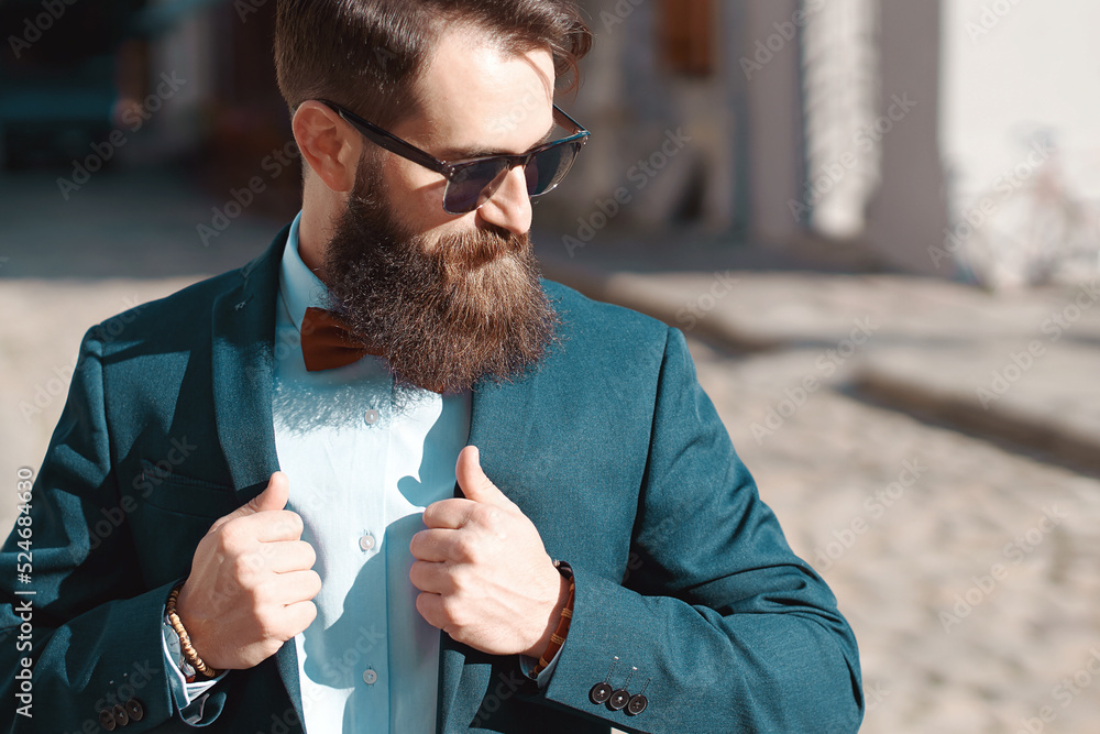 Stylish man with beard wearing a jacket, shirt and bow tie