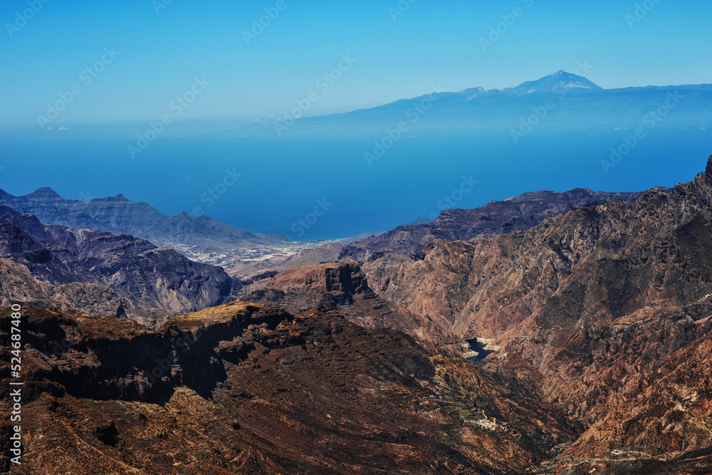 Mountains on the island Gran Canaria with clouds, island Tenerife  and volcano Tejde on the background 