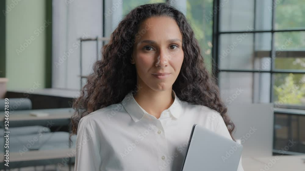 Female portrait closeup attractive woman perspective worker manager secretary representative agent looking at camera standing in office young successful confident hispanic businesswoman posing indoors