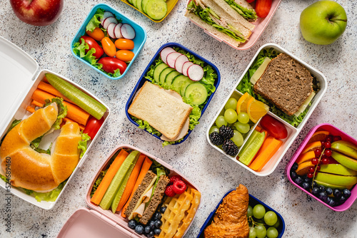 Shot of school lunchboxes with various healthy nutritious meals on stone background