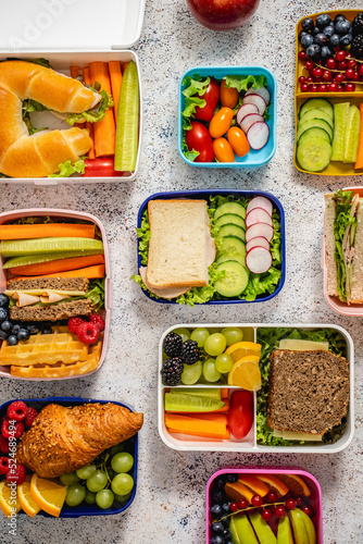Shot of school lunchboxes with various healthy nutritious meals on stone background