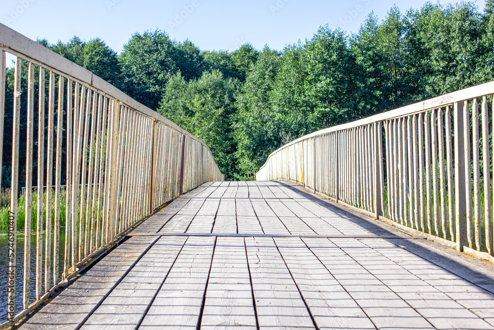 Old wooden bridge. Bridge over river. Yellow bridge in the summer in the park, forest. Old wooden bridge. Bridge over river. Yellow bridge in the summer in the park, forest.