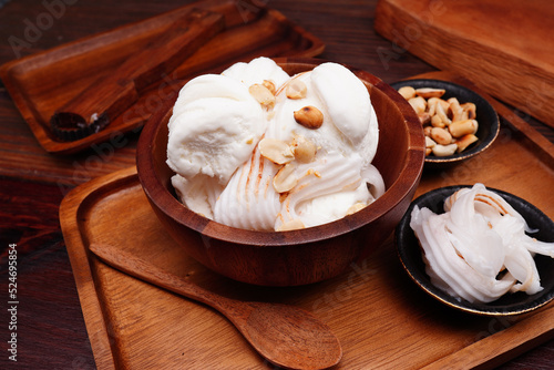 Coconut milk ice cream cup, round balls and young coconut Garnish with cooked roasted peanuts. (spot focus)