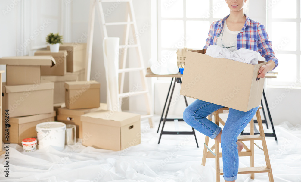 A beautiful single young woman unpacking boxes and moving into a new home A beautiful single young woman unpacking boxes and moving into a new home