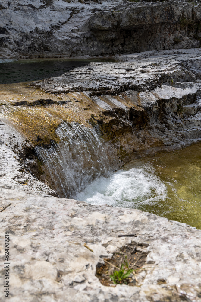 Natural path of Val Falcina at Valle del Mis in Italy. Cadini of Brenton, Sospirolo, with blue azure clear water and multiple waterfalls along the way down