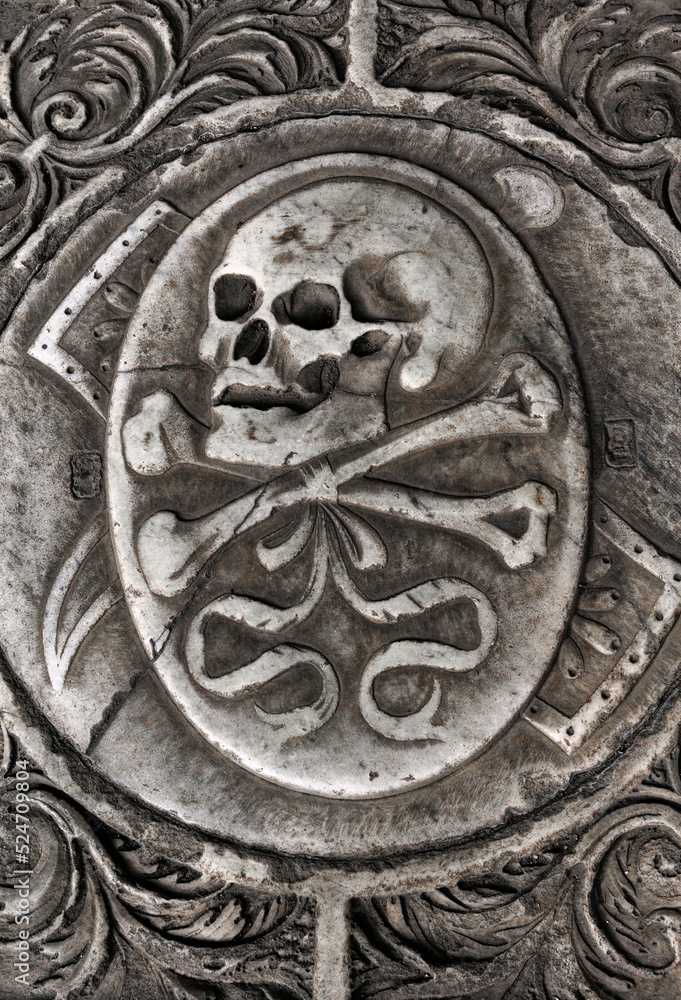 Skull and crossed bones motif on grave slab inside the Camposanto cemetery of the Campo dei Miracoli, Pisa, Tuscany, Italy