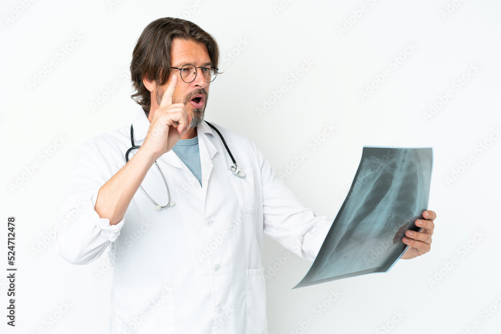 Senior dutch man isolated on white background wearing a doctor gown and holding a bone scan Senior dutch man isolated on white background wearing a doctor gown and holding a bone scan