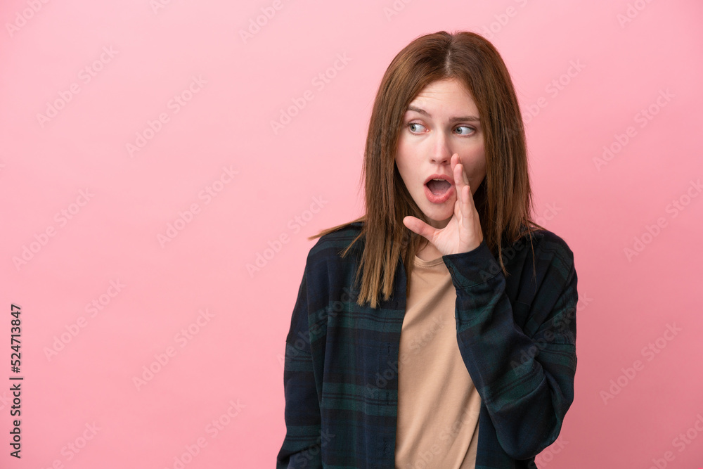 Young English woman isolated on pink background whispering something with surprise gesture while looking to the side Young English woman isolated on pink background whispering something with surprise gesture while looking to the side