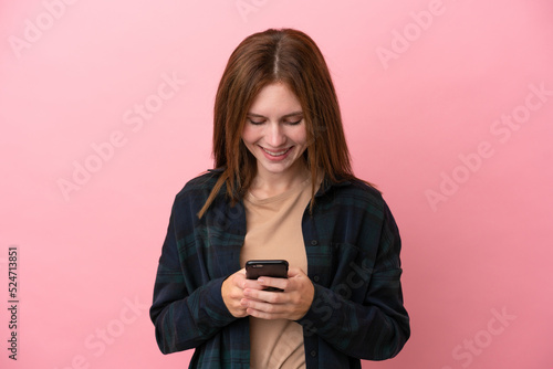 Young English woman isolated on pink background sending a message with the mobile