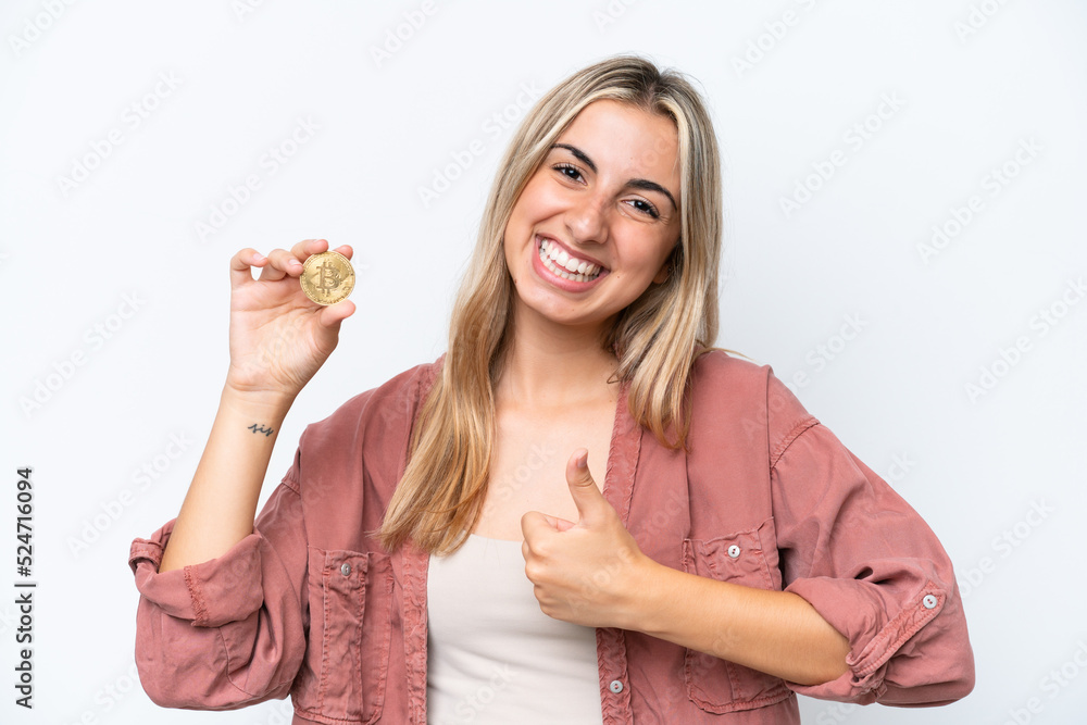 Young caucasian woman holding a Bitcoin isolated on white background with thumbs up because something good has happened