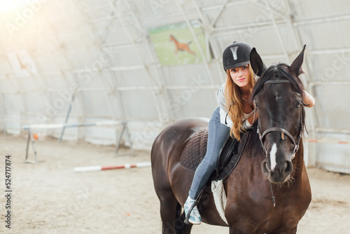 Fotografija beautiful blond professional female jockey standing near horse