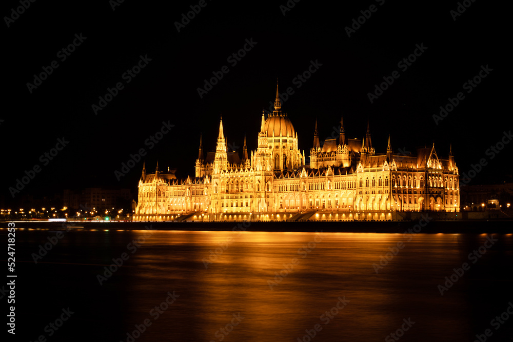 Hungarian Parliament Building or Országház in front of the Danube river at night. Beautiful night landscape with an illuminated monument. Summer landscape scene from the city of Budapest, Hungary