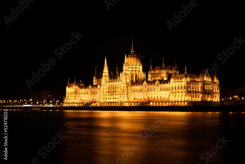 Hungarian Parliament Building or Országház in front of the Danube river at night. Beautiful night landscape with an illuminated monument. Summer landscape scene from the city of Budapest, Hungary