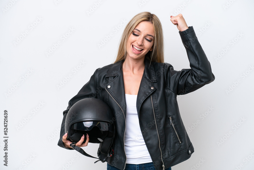 Pretty blonde woman with a motorcycle helmet isolated on white background celebrating a victory Pretty blonde woman with a motorcycle helmet isolated on white background celebrating a victory