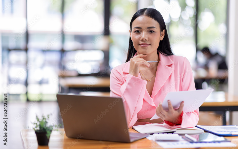 Business Asian woman working in the workplace with documents on her desk, doing planning analyzing the financial report, business plan investment, finance analysis concept Business Asian woman working in the workplace with documents on her desk, doing planning analyzing the financial report, business plan investment, finance analysis concept