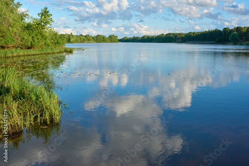 Landscape of the river with reflection of blue sky with clouds.