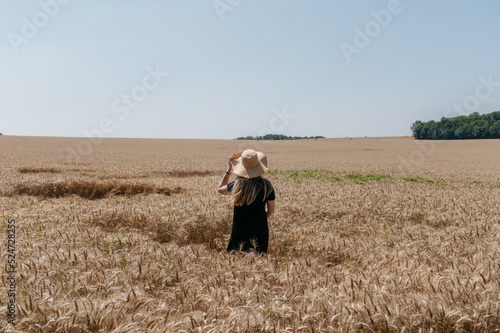 Woman with hat in field of wheat in countryside