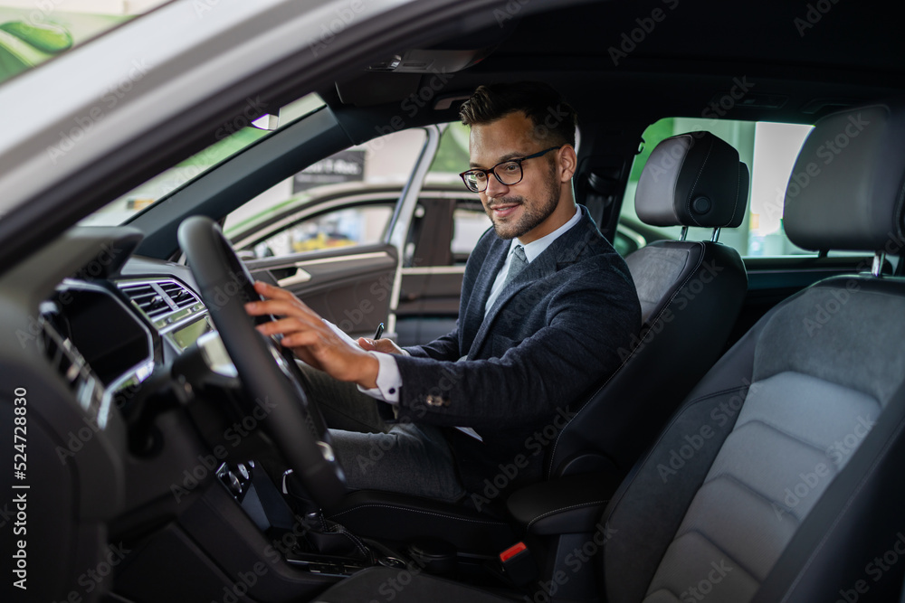 Car seller working in showroom and quality control checking of car details for the last time before buyer comes.